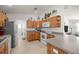 Functional kitchen with ample wood cabinets, white appliances, and a breakfast bar at 516 Junction Pl, The Villages, FL 32163