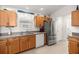 Well-lit kitchen featuring wood cabinets, stainless steel appliances and easy access to the laundry room at 516 Junction Pl, The Villages, FL 32163