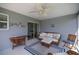 Enclosed lanai featuring comfortable seating, ceiling fan, and glass sliding door to the home's interior at 516 Junction Pl, The Villages, FL 32163