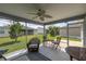 Large screened in lanai with seating, ceiling fan, and a view of the backyard and neighboring homes at 516 Junction Pl, The Villages, FL 32163