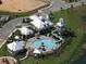 Aerial view of community pool, waterslide, cabanas, and meticulous landscaping at 520 Rainbow Springs Loop, Groveland, FL 34736