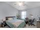 Well-lit bedroom with a comfortable bed, large window, and a desk for work or study at 520 Rainbow Springs Loop, Groveland, FL 34736