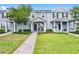 Inviting two-story townhome with well-manicured lawn and charming front porch seating at 520 Rainbow Springs Loop, Groveland, FL 34736