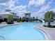 Community pool with a water slide, surrounded by palm trees and lounge chairs at 520 Rainbow Springs Loop, Groveland, FL 34736