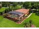 Aerial view of home highlighting the screened pool and verdant backyard at 5235 Greens Dr, Lady Lake, FL 32159