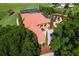 An aerial view of a beautiful estate with landscaped gardens, a tiled roof, and a screened-in lanai at 5235 Greens Dr, Lady Lake, FL 32159