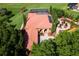 Aerial view showcasing the home's unique architecture, tile roof, pool, garden, and expansive lot at 5235 Greens Dr, Lady Lake, FL 32159