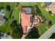 Beautiful aerial view of home featuring a terracotta tile roof, screened-in pool, and a manicured lawn at 5235 Greens Dr, Lady Lake, FL 32159