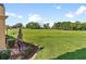 Spacious backyard view towards the golf course featuring a decorative horse statue at 5235 Greens Dr, Lady Lake, FL 32159