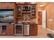 Home bar area boasts custom cabinetry, a wine fridge, and elegant display shelves for glassware at 5235 Greens Dr, Lady Lake, FL 32159
