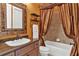 Well-appointed bathroom features a vanity with sink and a shower/tub combination with stylish curtain at 5235 Greens Dr, Lady Lake, FL 32159