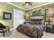 Inviting bedroom featuring a patterned bed, accent mural, and a ceiling fan at 5235 Greens Dr, Lady Lake, FL 32159