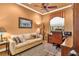 Comfortable bedroom offers a ceiling fan, neutral walls, and plush seating area with a sofa at 5235 Greens Dr, Lady Lake, FL 32159