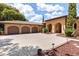 Spacious driveway leading to a three-car garage with arched doorways and manicured landscaping at 5235 Greens Dr, Lady Lake, FL 32159