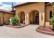 Beautiful front entrance with arched doorways, stone walkway, and manicured landscaping at 5235 Greens Dr, Lady Lake, FL 32159