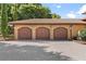 Three-car garage featuring arched doorways, exterior sconces, and decorative statues at 5235 Greens Dr, Lady Lake, FL 32159