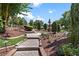 Lush garden featuring a stone pathway, manicured greenery, and decorative statues at 5235 Greens Dr, Lady Lake, FL 32159