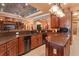 Spacious kitchen with brown cabinets, an island, stainless steel appliances, and stylish lighting at 5235 Greens Dr, Lady Lake, FL 32159