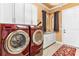 Modern laundry room includes updated washer and dryer with sink and storage cabinets at 5235 Greens Dr, Lady Lake, FL 32159