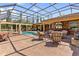 Beautiful outdoor area with a screened pool and full outdoor kitchen and seating area at 5235 Greens Dr, Lady Lake, FL 32159