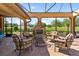 Inviting screened-in outdoor seating area with a stone fireplace and golf course views at 5235 Greens Dr, Lady Lake, FL 32159