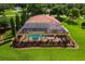 Aerial view of screened pool area with statues, landscaping, and spacious outdoor area at 5235 Greens Dr, Lady Lake, FL 32159