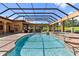 Stunning screened-in pool area with water feature, fireplace and a beautifully appointed outdoor kitchen at 5235 Greens Dr, Lady Lake, FL 32159