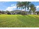 Large backyard featuring tropical landscaping, mature trees and a screened-in lanai at 5412 County Road 125, Wildwood, FL 34785