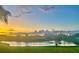 Scenic backyard view with a tranquil pond, lush green grass, and a colorful sunset, offering a serene and picturesque setting at 5412 County Road 125, Wildwood, FL 34785