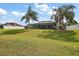 Expansive backyard with lush lawn, mature palm trees, and a screened-in lanai for outdoor enjoyment at 5412 County Road 125, Wildwood, FL 34785