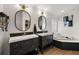 Bathroom featuring double sinks, modern fixtures, soaking tub and decorative wall art at 5412 County Road 125, Wildwood, FL 34785