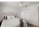 Comfortable bedroom featuring a ceiling fan, white walls, wood floors, and white bedding at 5412 County Road 125, Wildwood, FL 34785