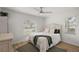 Inviting bedroom with two windows, white walls, wood flooring, and plush bedding at 5412 County Road 125, Wildwood, FL 34785