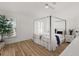 Serene bedroom with a canopy bed, minimalist design, and large windows providing natural light at 5412 County Road 125, Wildwood, FL 34785