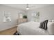 A bedroom with wood floors, a ceiling fan, white walls, and two windows that provide natural light at 5412 County Road 125, Wildwood, FL 34785