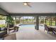 Inviting screened-in patio with view of the pool and lake, perfect for outdoor dining and relaxation at 5412 County Road 125, Wildwood, FL 34785