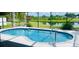 Sparkling screened-in pool with clear blue water, offering a refreshing escape with scenic views of the lake at 5412 County Road 125, Wildwood, FL 34785