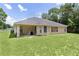 Home's backyard featuring a covered porch area for outdoor seating, complemented by a large lawn at 5460 Sw 103Rd Street Rd, Ocala, FL 34476