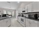 Bright kitchen features white cabinets, black countertops, modern appliances, and a breakfast nook at 5460 Sw 103Rd Street Rd, Ocala, FL 34476