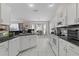 Bright kitchen features white cabinets, black countertops, modern appliances, and a breakfast nook at 5460 Sw 103Rd Street Rd, Ocala, FL 34476