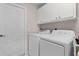 Clean laundry room featuring a washer, dryer, and built-in cabinets at 5460 Sw 103Rd Street Rd, Ocala, FL 34476