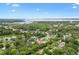 A beautiful, scenic aerial view of a home near a lake and surrounded by vibrant green trees at 601 S 12Th St, Leesburg, FL 34748