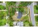 An aerial view shows the property within lush greenery, and adjacent to neighborhood streets at 601 S 12Th St, Leesburg, FL 34748