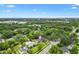 An aerial view of a charming home nestled within a lush green neighborhood under a bright blue sky at 601 S 12Th St, Leesburg, FL 34748