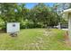 A well-kept lawn features lush greenery, storage shed and a truck behind the fence at 601 S 12Th St, Leesburg, FL 34748