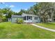 Beautiful single-story house featuring well-kept lawn, ample greenery and a sidewalk leading to a screened entrance at 601 S 12Th St, Leesburg, FL 34748