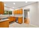 Galley style kitchen boasts stainless steel appliances, light countertops, and wood cabinets at 601 S 12Th St, Leesburg, FL 34748