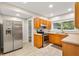 Well-lit kitchen with stainless steel appliances, wood cabinets and tile flooring at 601 S 12Th St, Leesburg, FL 34748