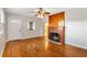 Bright living room with hardwood floors, a ceiling fan, and a beautiful wood-trimmed fireplace at 601 S 12Th St, Leesburg, FL 34748