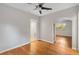 Living room with hardwood floors, ceiling fan and open archway to additional room at 601 S 12Th St, Leesburg, FL 34748